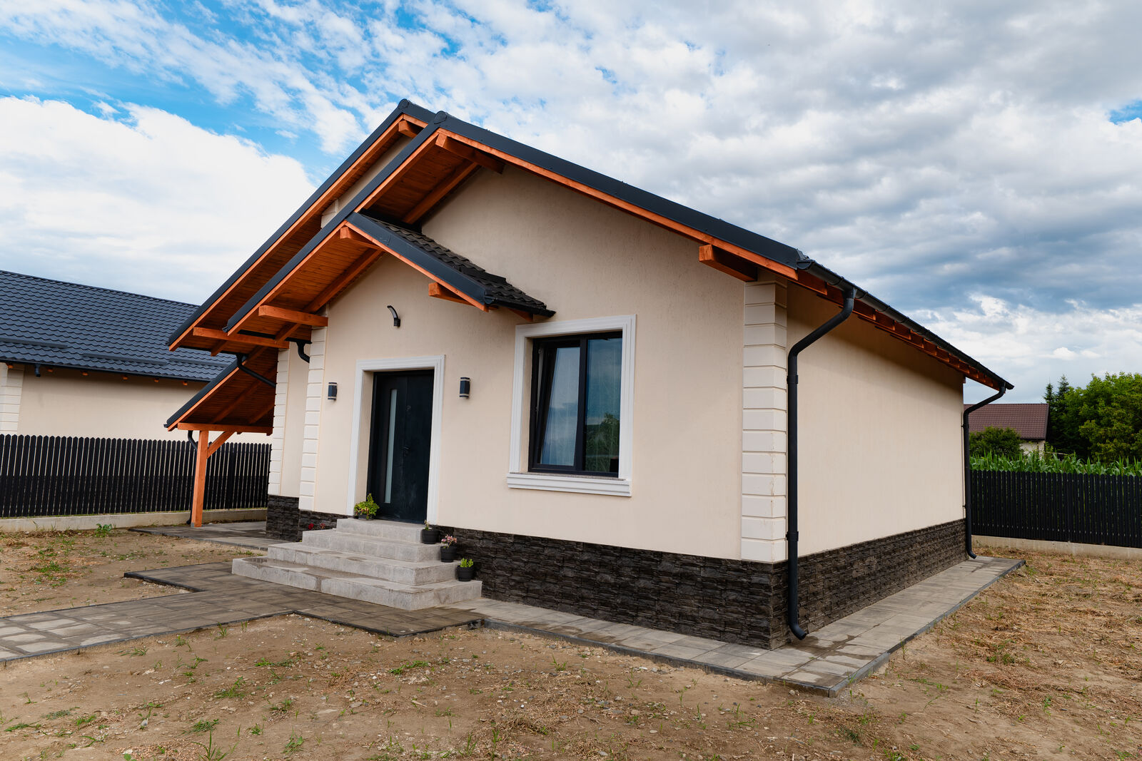 Casă finalizată VTZ Residence — fațada principală în lumina apusului, cu alee pavată